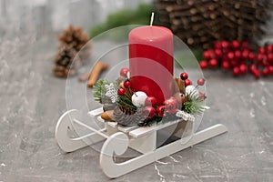 Christmas composition with candle in small sleigh