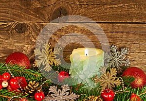 Christmas composition with a candle on a wooden background.