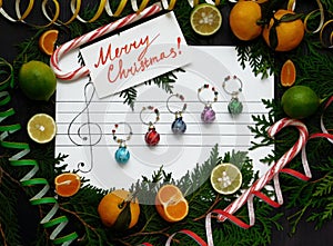 Christmas composition. Christmas decoration balls are arranged on the paper like music notes