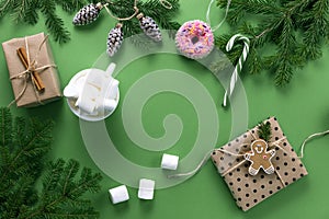 Christmas composition. Christmas decorations, fir branches and marshmallows on a green background.