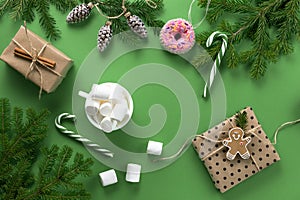 Christmas composition. Christmas decorations, fir branches and marshmallows on a green background.