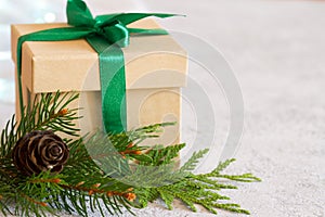 Christmas composition. Christmas gift, jute, pine cone and fir twigs on light background