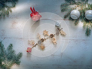 Christmas composition. Christmas gift, pine cones, fir branches on a wooden white background. Wooden decorations and a branch with