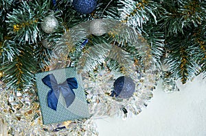 Christmas composition with Christmas tree branches in blue and silver balls and blue gift box