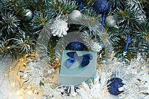 Christmas composition with Christmas tree branches in blue and silver balls and blue gift box