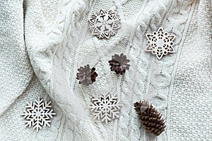 Christmas composition with cone, snowflakes on white knitted sweater. Holiday card. Vintage style.