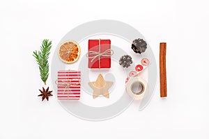 Christmas composition with craft red gifts, fir tree branch, cinnamon stick, dry sliced orange, star anise, pine cones, wooden