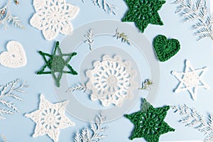Christmas composition of crocheted white snowflakes and stars on white background. Top view, flat lay, copy space.