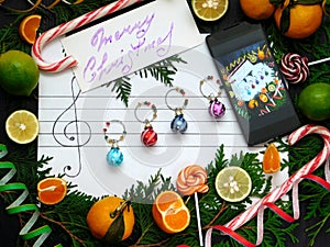 Christmas composition. Decoration balls are arranged on the paper like music notes. Christmas melody concept.