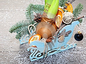 Christmas composition in decorative sleigh with pine branches, cones, dried orange slices, cinnamon, ball and amaryllis bulb