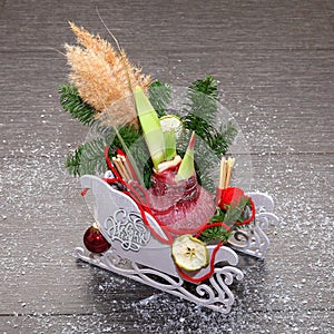 Christmas composition in decorative sleigh with pine branches, dried apple slices, cinnamon and red amaryllis bulb