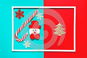 Christmas composition with decorative snowman, lollipop and snowflakes colorful background with white frame. Winter holiday