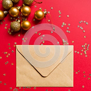 Christmas composition. Envelope, toys on red background with golden confetti. new year concept. Greeting card, xmas celebration