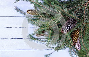 Christmas composition with fir branches and cones on white aged wooden background. New Year festive design template.