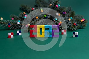 Christmas composition with a fir tree branch and colorful cubes from a children's constructor. Namber 2022 from magnet