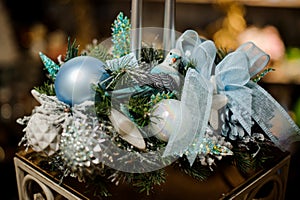 Christmas composition of fir-tree branches, candles, tapes, blue and silver toys