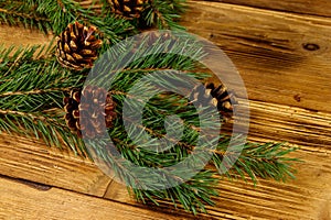 Christmas composition with fir tree branches and cones on wooden background