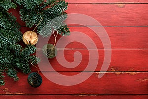 Christmas composition. Christmas fir tree branches with pine cones and papers rustic balls on wooden red rustic background