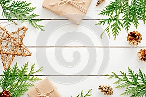 Christmas composition. Frame made of Christmas decorations and fir tree branch on wooden white table. Flat lay, top view, copy
