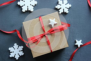 Christmas composition. Gift box with red satin ribbon on a black background. Christmas decor.