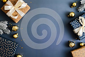 Christmas composition with gift boxes, fir branches, gold baubles on dark blue background. Top view, Flat lay. Xmas banner mockup