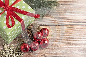 Christmas composition. Gift, for tree branches, red balls decorations on wooden background.
