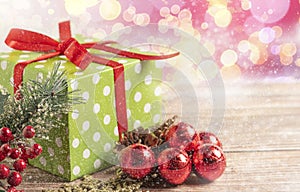 Christmas composition. Gift, for tree branches, red balls decorations on wooden background.