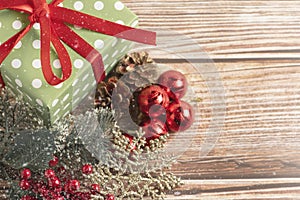 Christmas composition. Gift, for tree branches, red balls decorations on wooden background.