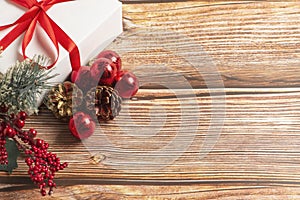 Christmas composition. Gift, for tree branches, red balls decorations on wooden background.