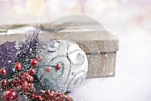 Christmas composition. Gift, for tree branches, white balls decorations on bokeh background.
