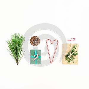 Christmas composition of gifts with candy cane, pine branch and pine cone on white background. New year concept. Flat lay. Top vie