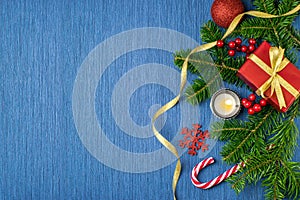 Christmas composition with gifts, gold tinsel, pine cones, candle, fir branches and snowflakes on a blue background