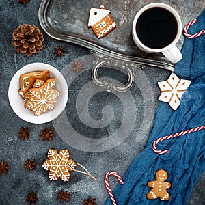 Christmas composition. Gingerbread, candy cane and coffee cup on dark background. New year concept