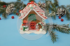 Christmas composition gingerbread house on the blue background of a winter spruce. Close-up. The concept of Christmas and New Yea