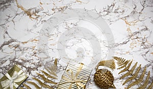 Christmas composition - gold gifts, Xmas bauble, fern foliage, balls on marble background with stars, lights. Creative banner new