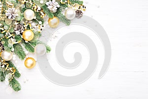 Christmas composition with golden baubles on white wooden background.