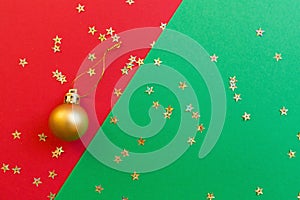 Christmas composition. Golden toy on red and green background with golden confetti. new year concept. Greeting card, xmas