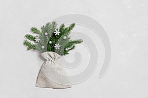 Christmas composition on a gray background. New Year bouquet with fir branches and silver snowflakes. View from above. Space for