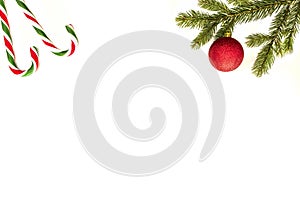 Christmas composition. Green fir tree branch, Xmas decoration and candy canes on white background. Top view, flat lay