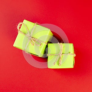 Christmas composition. Green gift boxes tied with twine on a red background. View from above. a Christmas gift