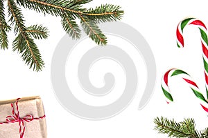 Christmas composition. Green tree twings, Xmas gifts and candy canes on white background. Top view, flat lay. Copy