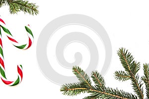 Christmas composition. Green tree twings, Xmas gifts and candy canes on white background. Top view, flat lay. Copy