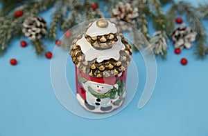 Christmas composition lantern snowman on the blue background of a winter spruce. Close-up. The concept of Christmas and New Year.