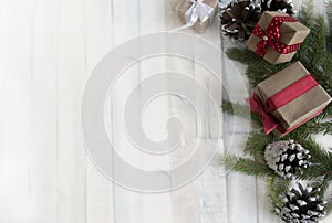 Christmas composition on a light background with gift boxes, with a red ribbon with fir branches, toys, copy space for your