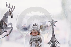 Christmas composition on a light background. Two glasses, a Christmas tree, a deer.