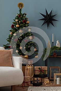 Christmas composition in the living room interior with beautiful decoration, consola with spruce, christmas tree, white armchair