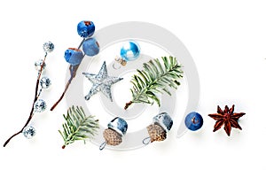 Christmas composition made of blue berries, silver star, baubles and green fir branch isolated on white background