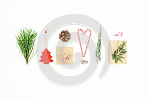 Christmas composition made of gifts with candy cane, pine branch and pine cone on white background. New year concept. Flat lay.