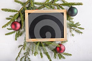 Christmas composition. New Year background. Festive xmas fir tree branches and blank chalkboard. Top view. Copy space