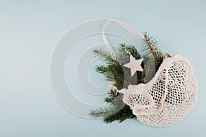 Christmas composition. New Year or Christmas flat lay, top view with trend eco friendly modern cotton net bag with fir branches